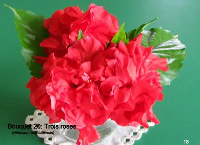 a bunch of red flowers in a white vase at Coin de Paradis,Pavillon Doucimar in Porto Novo