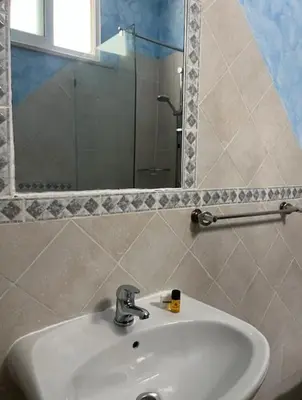 a bathroom with a white sink and a mirror at Vivenda Viviani in Praia