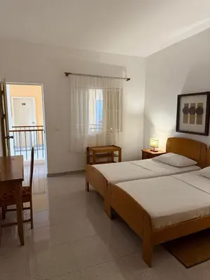 a bedroom with two beds and a table and a piano at Pousada Praia Maria in Praia