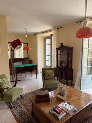 a living room with a table and a piano at Pousada Praia Maria in Praia