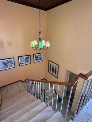 a room with a staircase and a chandelier at Pousada Praia Maria in Praia