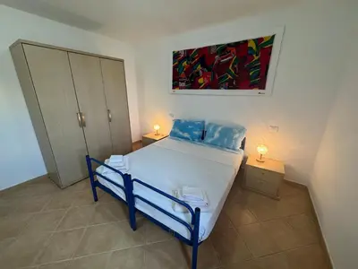 a bedroom with a bed and a painting on the wall at Holiday Properties Tres Caravelas in Santa Maria