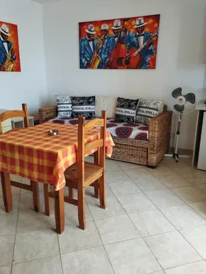 a dining room with a table and a couch at Holiday Properties Tres Caravelas in Santa Maria