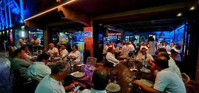 a group of people sitting at a table in a restaurant at Ocean Suites in Santa Maria