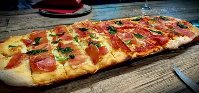 a pizza sitting on top of a wooden table at Ocean Suites in Santa Maria
