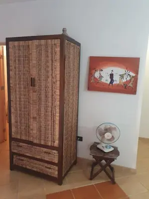 a large wooden cabinet in a room with a table at Holiday Properties Oleandro Ocean in Santa Maria
