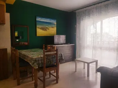a dining room with a table and a green wall at Ca' Francisca in Santa Maria
