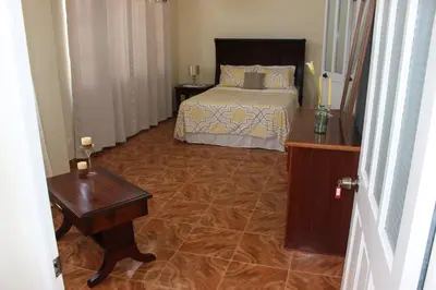 a bedroom with a bed and a wooden table and a table sidx sidx at Hotel Cruz Grande-Brava in Vila Nova Sintra