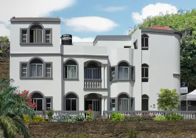 a white house with trees in the background at Hotel Cruz Grande-Brava in Vila Nova Sintra