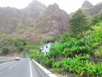 a car driving down a road with mountains in the background at Damontanha in Ribeira Grande