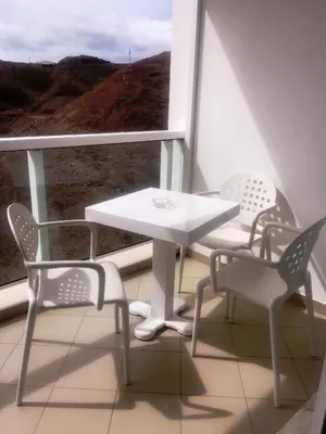 a table and two chairs in a room with a window at Suite Mariposa Sospesa Sul Mare in Mindelo