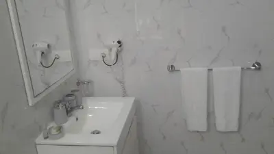 a white bathroom with a sink and a mirror at Vista Mar in Tarrafal