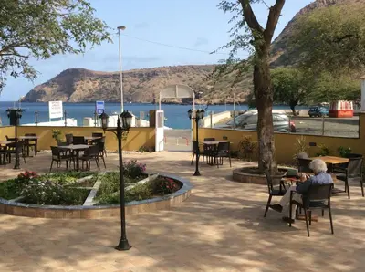 a person sitting in a chair at a restaurant with the water at Vista Mar in Tarrafal