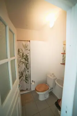 a bathroom with a toilet with a wooden seat at Música do Mar in Ponta do Sol