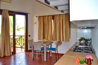 a kitchen with a table and chairs and a stove at Porto Antigo Hotel BB in Santa Maria