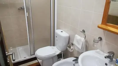 a bathroom with a toilet and a sink and a shower at Basic Hotel in Mindelo