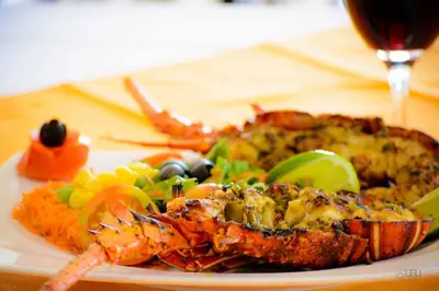 a plate of food with shrimp and vegetables on a table at Restaurante Residencial Nova Cidade in Porto Novo