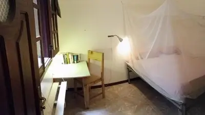 a desk with a lamp and a chair in a room at Private Holiday Apartment in Tarrafal