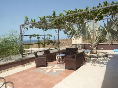 a patio with chairs and a table on a roof at Villa Halcyon Caboverde in Cidade Velha