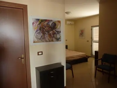 a room with a bed and a painting on the wall at Villa Halcyon Caboverde in Cidade Velha