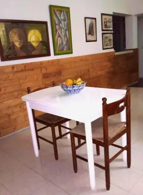 a white table with a bowl of fruit and two chairs at My Place Apt#1 in Praia