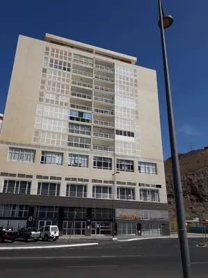 a large building with cars parked in front of it at @Georgette in Mindelo