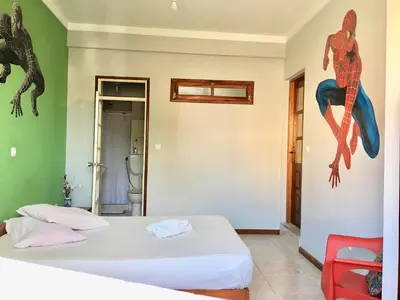 a bedroom with two beds and a lizard on the wall at Laginha Beach Guest House in Mindelo