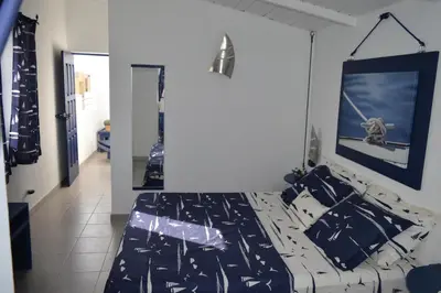 a bedroom with a bed with black and white sheets at Yacht Club Sal in Palmeira