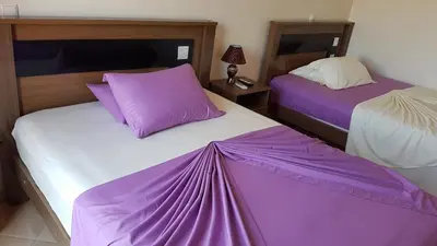 two purple and white beds in a room at Hotel Ocean View & Restaurante Seafood in São Filipe