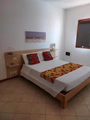 a bedroom with a large bed with red pillows at Aparthotel Ca Bonita in Sal Rei