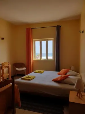 a bedroom with a large bed and a window at Casa D'Mar in Ponta do Sol