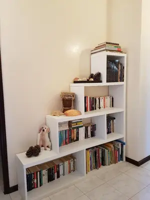 a white book shelf filled with books at Casa D'Mar in Ponta do Sol