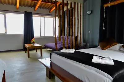 a hotel room with two beds and a couch at kasa Tambla in Ponta do Sol