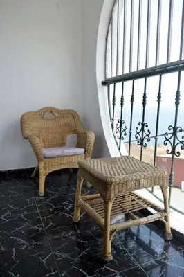 a room with a chair and a bench and a window at Hotel Miramar Fogo Brava in São Filipe