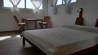 a bedroom with a bed and a table and two chairs at Casa Patio in Tarrafal