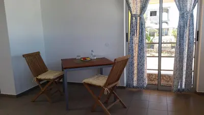 a table and two chairs in a room with a window at Casa Patio in Tarrafal