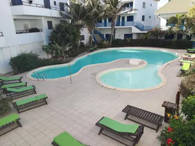 a swimming pool with chaise lounges and chairs next to a building at Residence Amanda with pool in Santa Maria