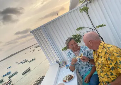 a man and a woman eating food on a beach at Nos Kasa in Sal Rei