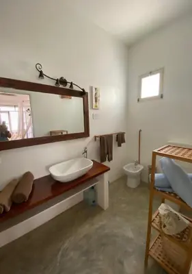 a bathroom with a sink and a mirror and a toilet at Nos Kasa in Sal Rei