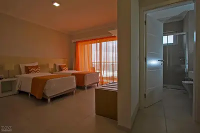a hotel room with two beds and a bathroom at Tiduca Hotel in Ponta do Sol