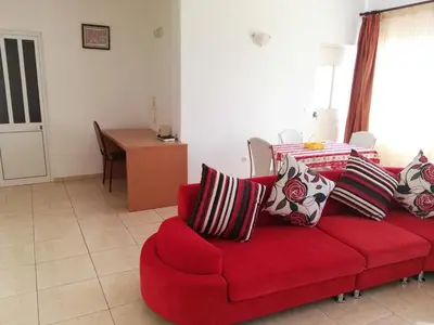 a red couch with pillows on it in a living room at Casa da Luz - Appartement in Mindelo