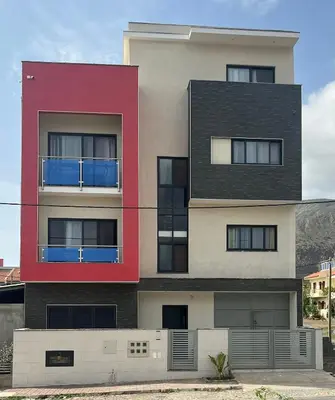 a tall building with red and black at Tarrafal Guest House in Tarrafal