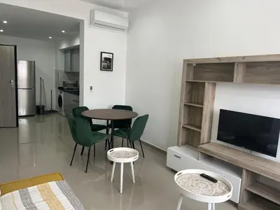 a living room with a table and chairs and a television at Tarrafal Guest House in Tarrafal