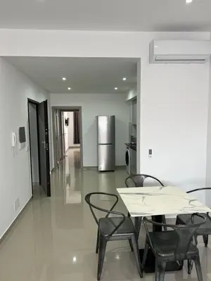 a dining room with a table and chairs and a refrigerator at Tarrafal Guest House in Tarrafal