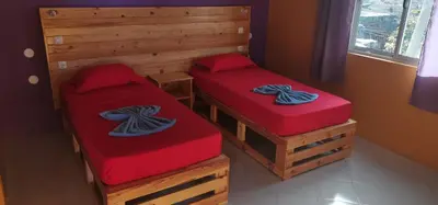 two twin beds in a room with red cushions at casa alcindo in Portela