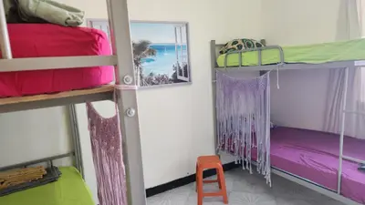 a room with two bunk beds and a stool at Meeting Point Hostels-Praia Beachwalk-NO CASH ACCEPTED-Also in Fogo & Tarrafal in Praia
