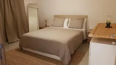 a bedroom with a large bed and a mirror at Elegant Modern Apartment with AirCond in Praia