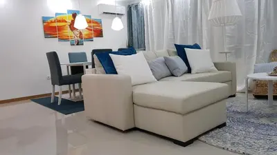 a living room with a white couch and a table at Elegant Modern Apartment with AirCond in Praia