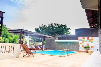 a patio with a swimming pool and chairs and a house at Pousada Quinta Ribeirinha in Cidade Velha