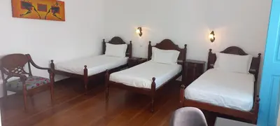 a room with two twin beds and a chair at Hotel Savana in São Filipe